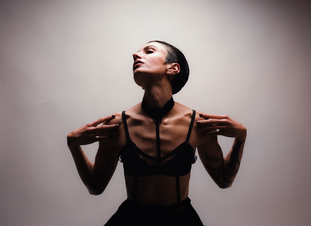 Editorial fashion portrait of Alia Kohlmann in a black skirt, head tilted back in expression, captured by Dario Hudon